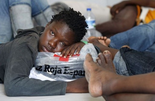 Would-be immigrants rest after arriving at the port of Motril