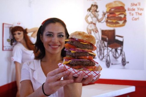 Waitress Mary Brasda poses with a “Quadruple Bypass Burger” at the Heart Attack Grill in Chandler