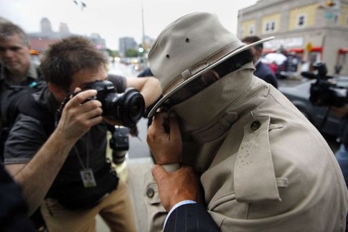 A man identified as Daniel Van Pelt, a New Jersey Assemblyman, tries to shield his face as he exits federal court after being one of the more than 40 people were arrested in a federal investigation of public corruption and international money laundering
