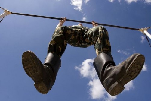 Belarussian border guard does chin ups during a training session at the Belyani border crossing west of Minsk