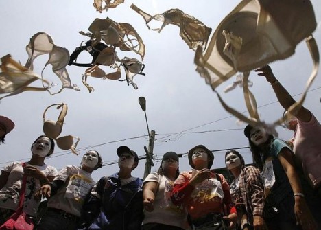 Dismissed workers of Triumph International Philippines throw bras in the air during a demonstration in front of the Department of Labour and Employment in Manila